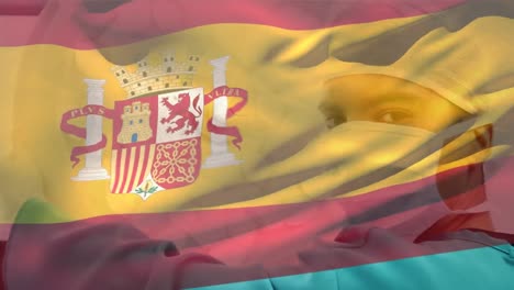 animation of flag of spain over biracial male surgeon with face mask