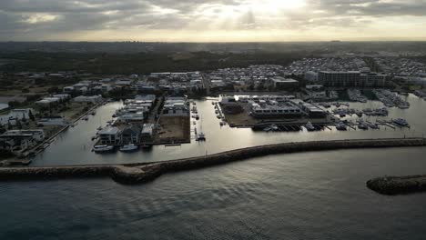 aerial view showing coogee port marina in perth city with parking boats and yachts at sunset time - cityscape in western australia in background - trecking shot