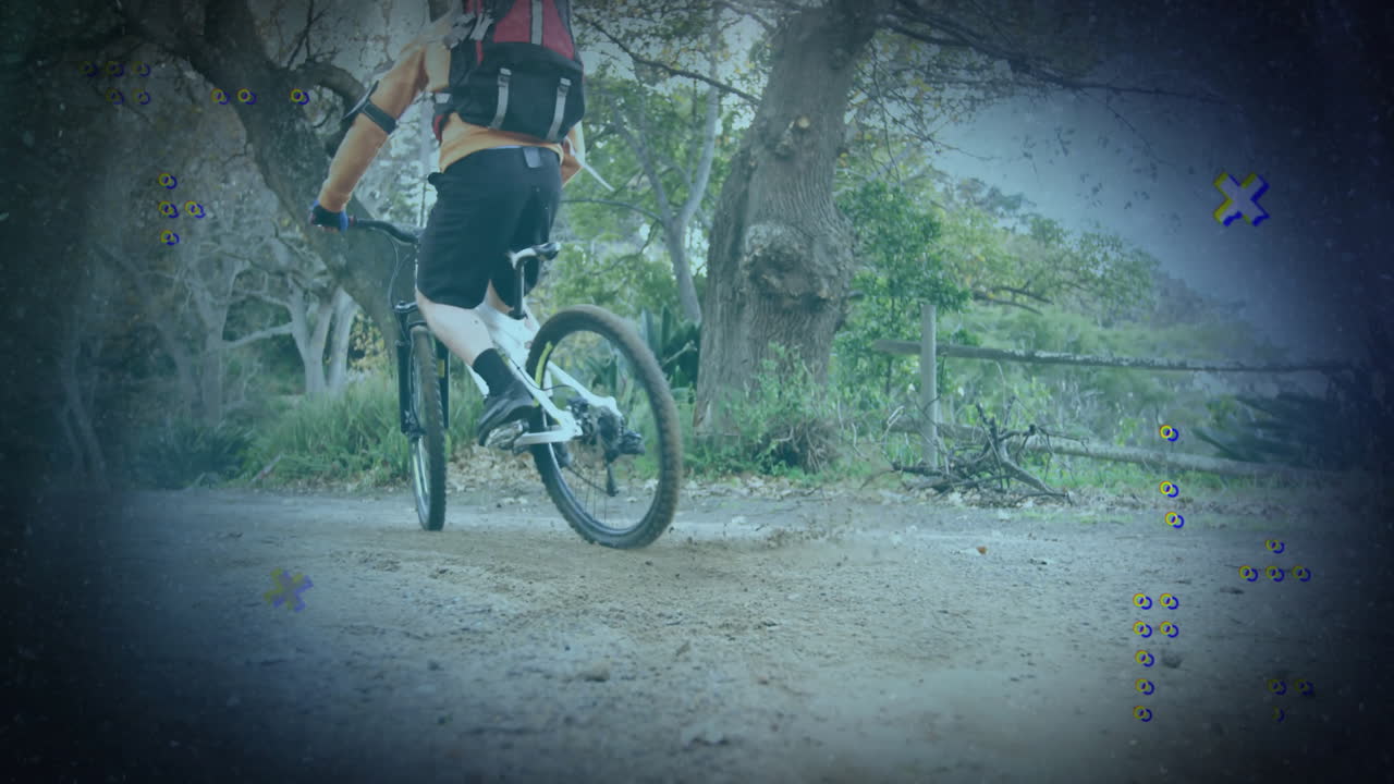 Male cyclist riding bike on forest trail, kicking up dust with animated fitness stats overlay