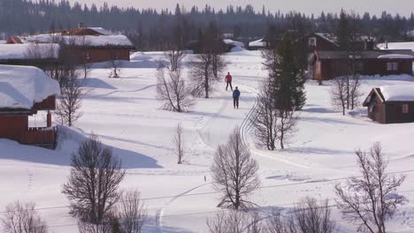 los esquiadores de fondo siguen un sendero a través de un pueblo en noruega