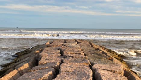 waves breaking in front of the granite jetty