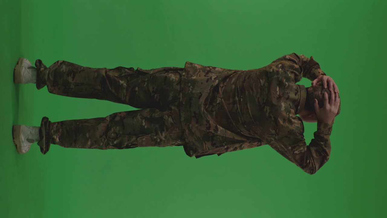 cuerpo completo vista trasera de angustiado soldado masculino asiático sosteniendo su cabeza teniendo dolor de cabeza mientras protege a su país de la guerra en el fondo de la pantalla verde