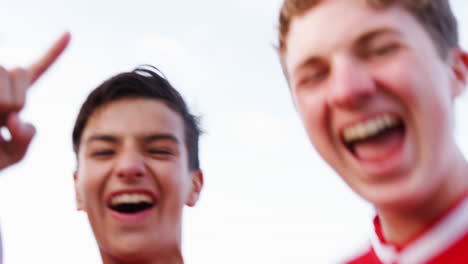 portrait of male high school soccer team running towards camera and celebrating