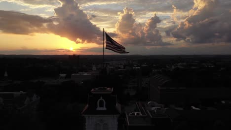 drone rodea una torre con una bandera estadounidense al atardecer