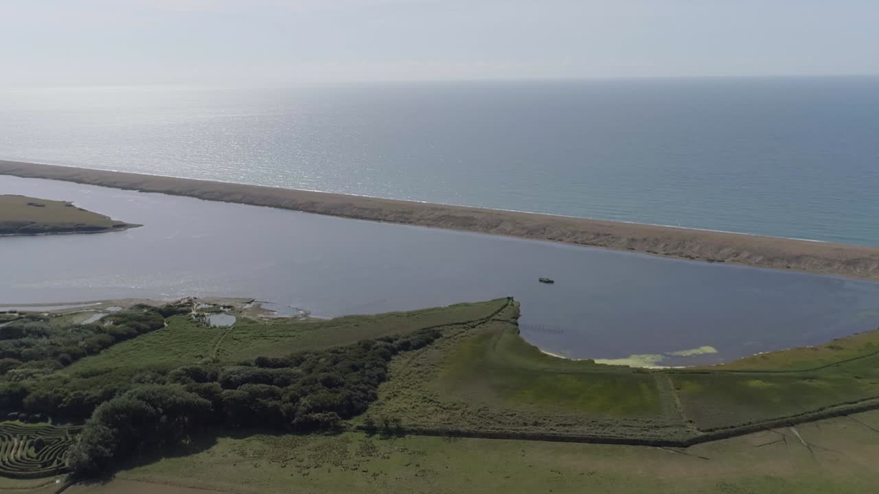 Tracciamento aereo in avanti dall'entroterra verso la laguna di Fleet ad Abbotsbury nel Dorset.
