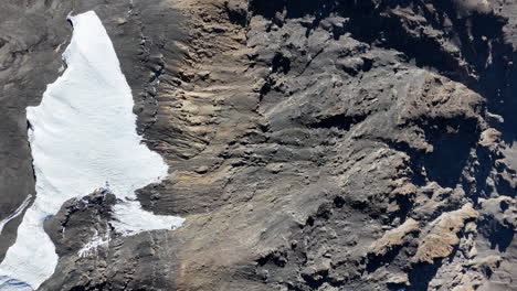 drone shot, downward angle of uhuru peak on mount kilimanjaro with the volcanic crater below. slowly panning aerial shot