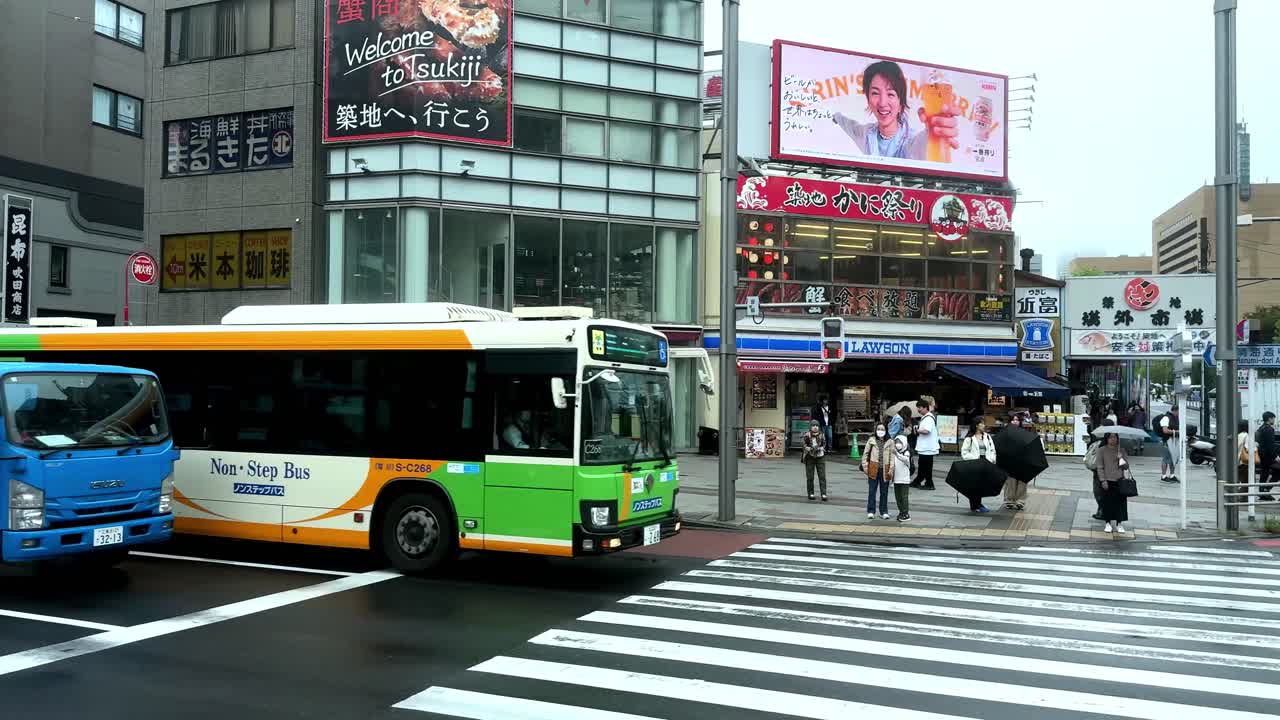 Busy Tokyo market street with shops, signage, and people walking under a blue entrance archway