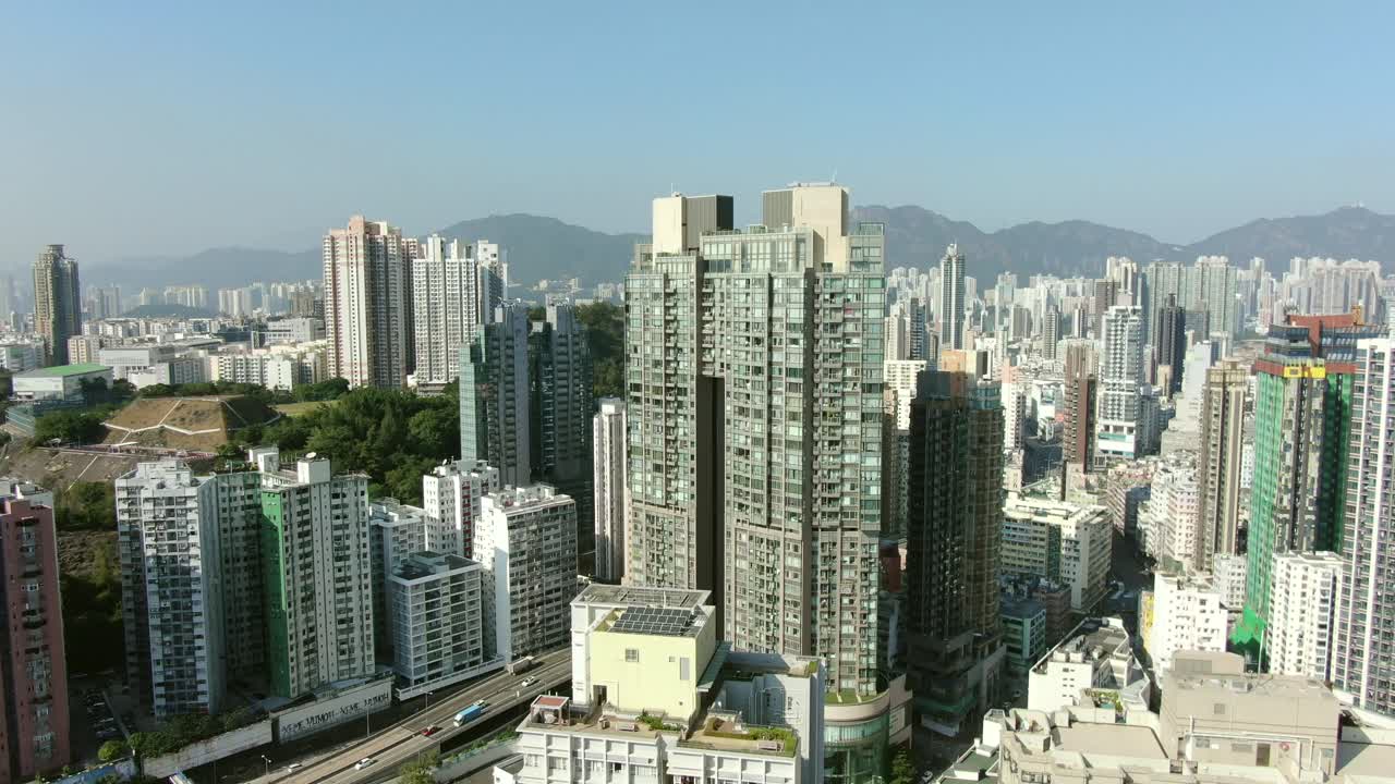 Imagem aérea do centro de Hong Kong com megarrarranha-céus residenciais e tráfego, em um belo dia