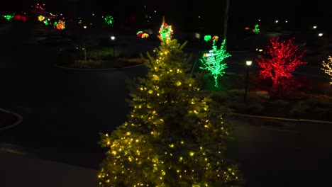 aerial orbiting shot of lighting christmas tree and christmas decoration along american road