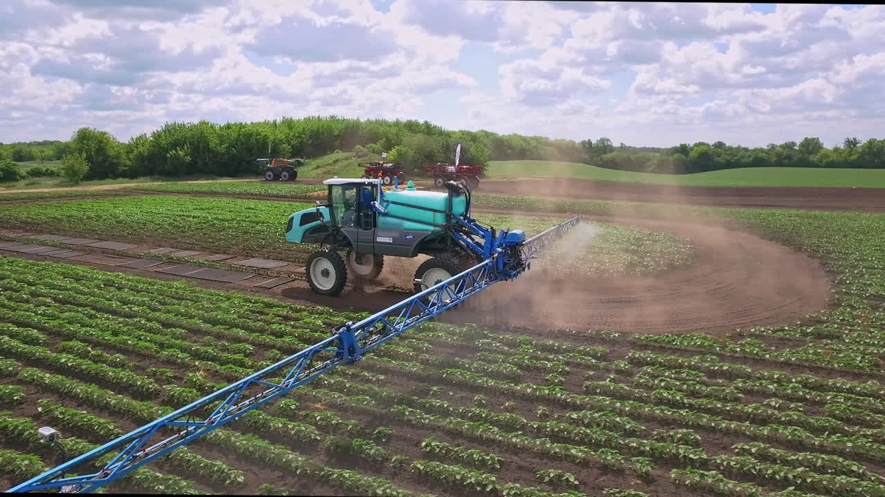 Irroratrice agricola che distribuisce fertilizzante su un campo coltivato. Industria agricola