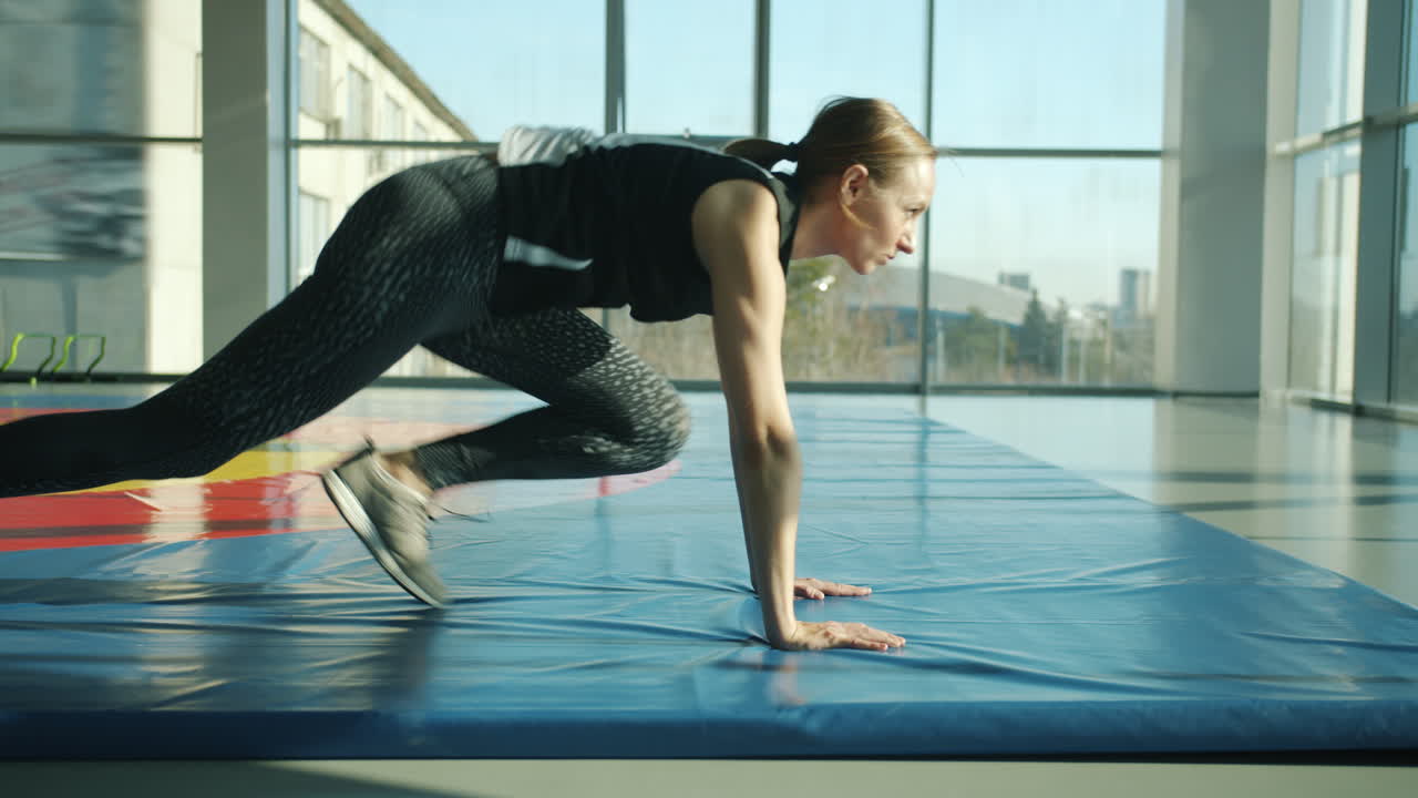 Woman Performing Burpees in Gym