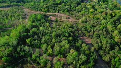 Off-Road-Bikes-Dirt-Tracks-in-the-middle-of-a-Green-Forest-Area,-Sunnyday