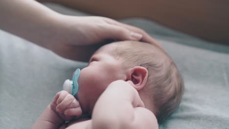 Liebevolle-Mutterhand-Streichelt-Und-Streichelt-Entzückenden-Neugeborenen-Jungen