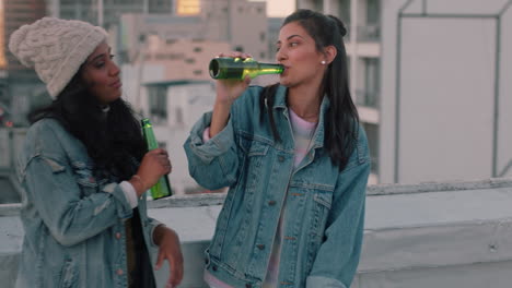 beautiful women friends hanging out on rooftop drinking alcohol chatting enjoying weekend party wearing stylish denim fashion