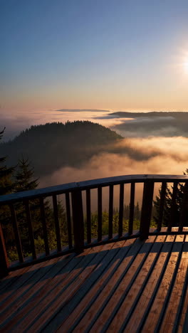 sunrise over misty mountain peaks from a wooden balcony