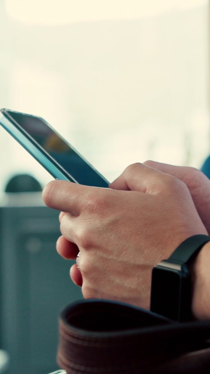 Persona che usa lo smartphone mentre viaggia sui mezzi pubblici