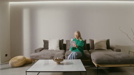 senior woman using tablet on couch