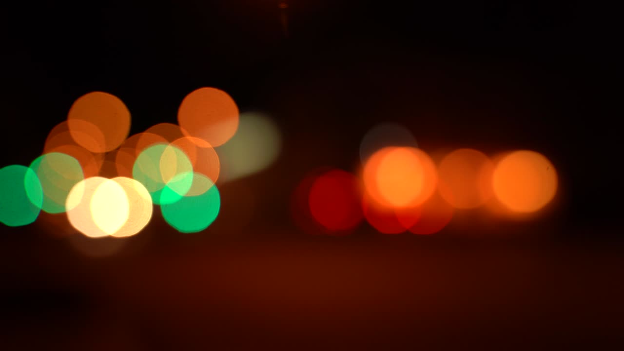 el tráfico de bokeh borroso en la carretera por la noche en una gran ciudad, hermosas luces quemando diferentes colores en la oscuridad.