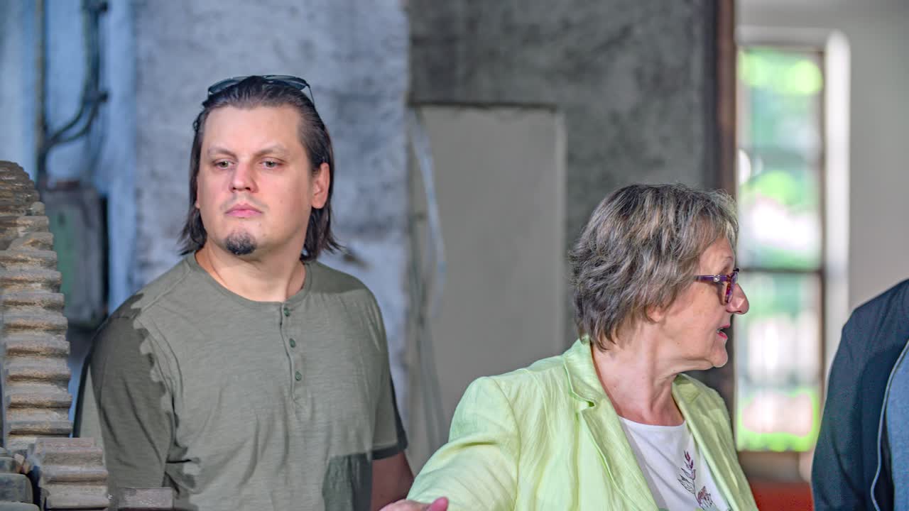 A woman guiding a tour and answering questions in the Iron Working museum, Slovenia
