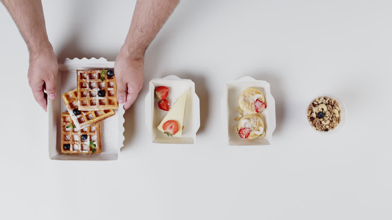 Hands Arranging Various Takeaway Breakfast and Dessert Items