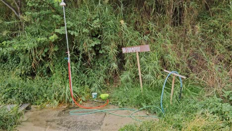 rustic outdoor shower with no shampoo sign