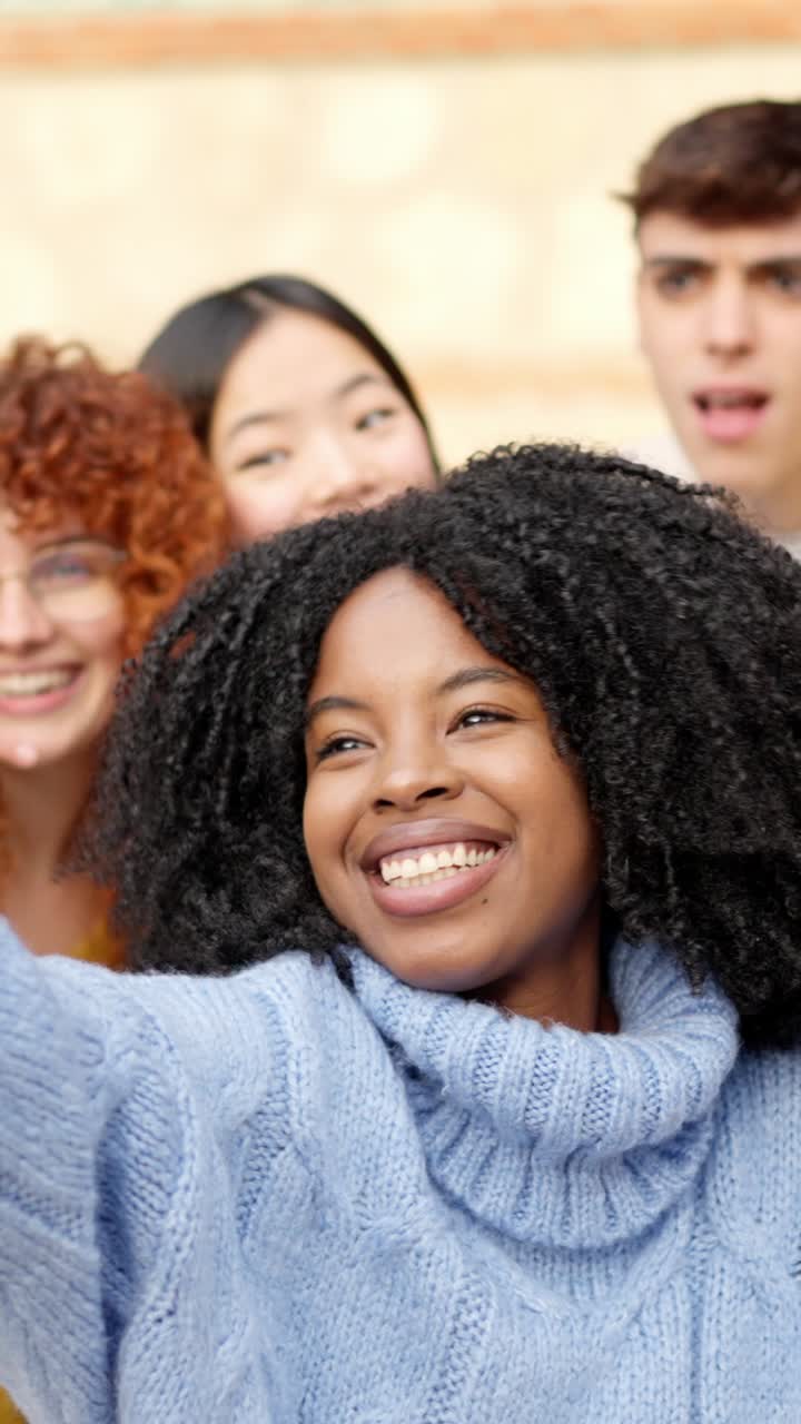 African girl taking a selfie with diverse friends outdoors