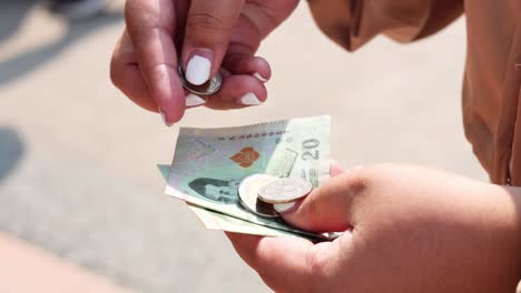 intercambio de dinero entre dos personas al aire libre
