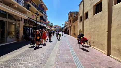 visitors stroll down a lively street in chania's historic old town, lined with shops and rustic architecture. chania, greece