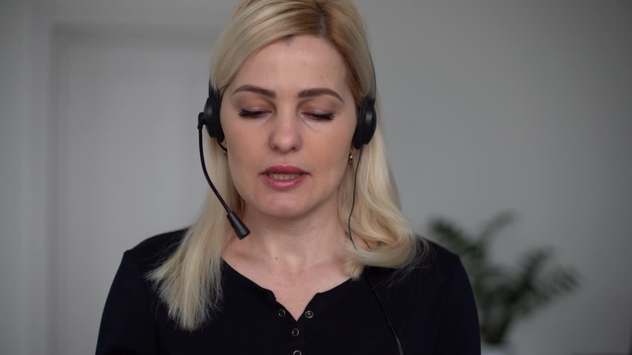 Kvinne med hodetelefoner snakker i videochat ved hjelp av bærbar datamaskin. Selvisolering under COVID-19-pandemien. Kvinne med nettstøtte
