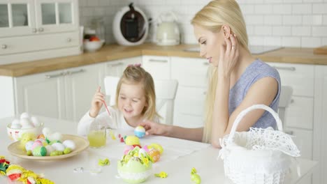 Lachende-Frau-Und-Kleines-Mädchen-Beim-Eierfärben