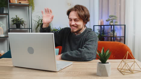 man sitting on home couch looking at camera making video conference call with friends or family