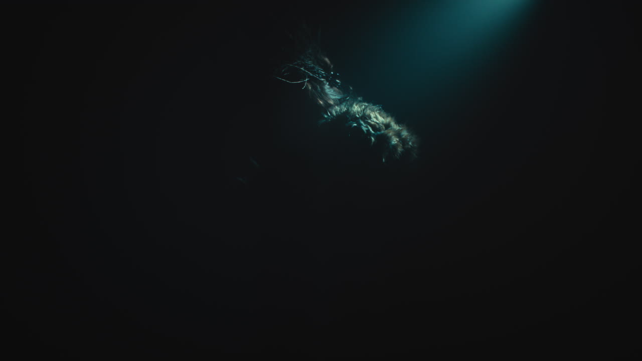 A creepy witch stands in the moody pose during the night storm