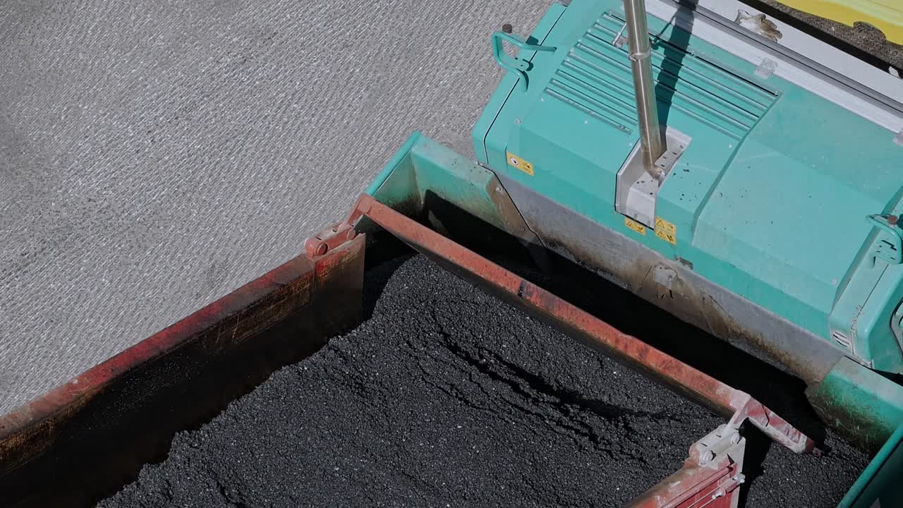 camión volquete de primer plano que pone asfalto el negro aplastado