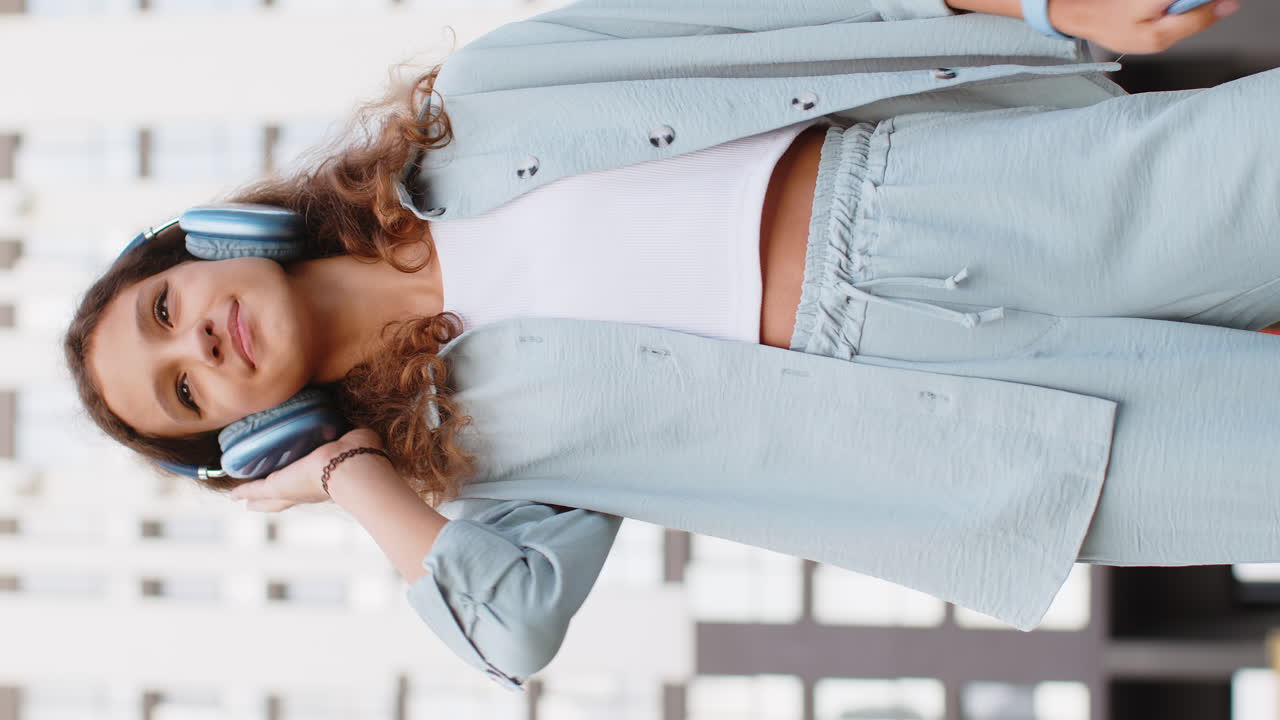 niño preadolescente feliz con auriculares inalámbricos eligiendo escuchar música bailando al aire libre en la calle de la ciudad