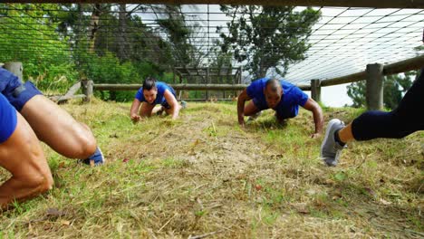 fit people crawling under the net during obstacle course 4k