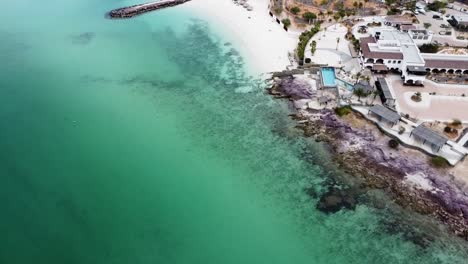 aerial view of a tourist paradise on the coast of playa el caymancito near la paz baja california sur, mexico overlooking the beautiful beach and turquoise sea with hots and dry landscape in summer