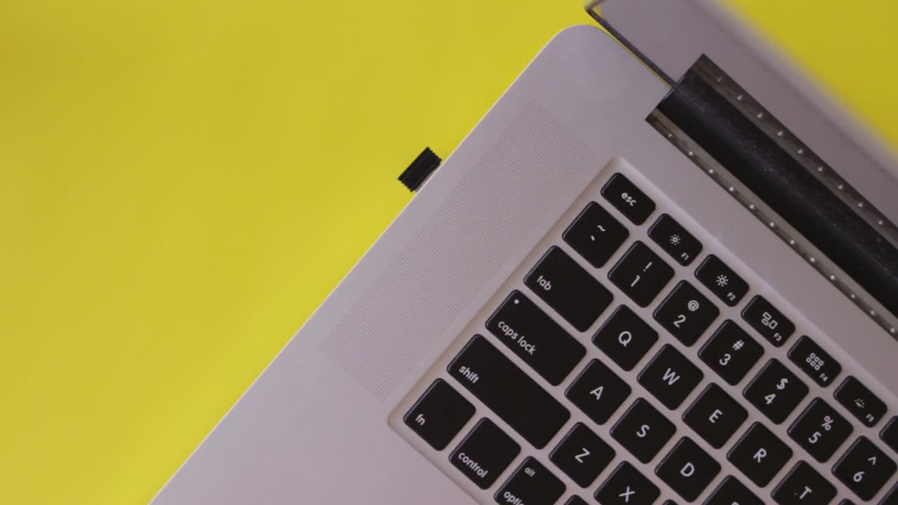 vista superior de las manos levantando un vaso de agua, bebiendo agua diariamente, escritura de trabajo con teclado portátil, hidratado, fondo amarillo, estático