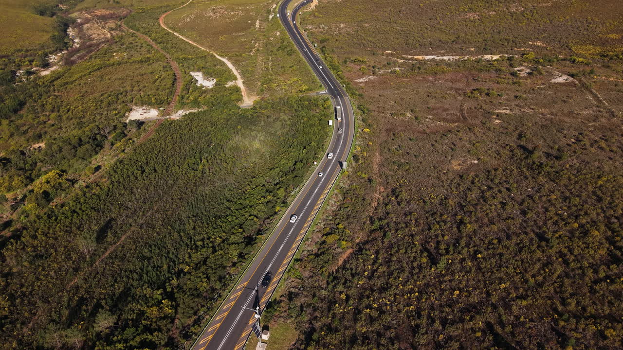 Traffic Over Winding Road Along Steep Rugged Hillside Near Cape Town, South Africa. Aerial Drone Shot