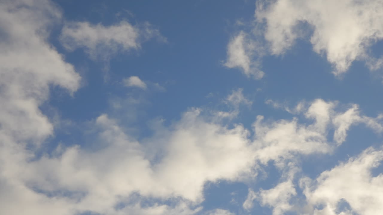 A fast rotating blue sky with white fluffy clouds. POV SHOT.