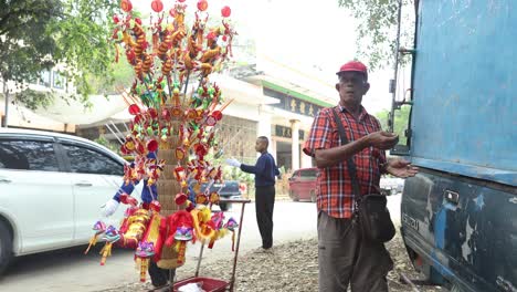 man with toy display walking by a blue wall