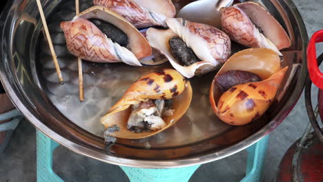 cerca de coloridos caracoles marinos frescos en un plato de metal