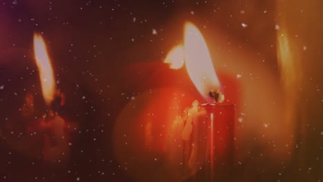 animación de nieve cayendo y manchas de luz sobre las velas en navidad