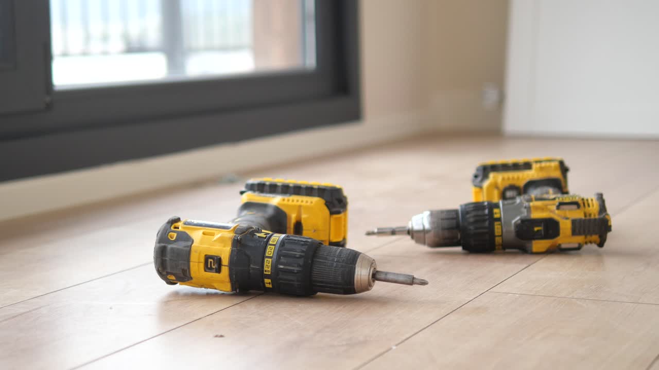 Three Yellow Drills on a Light Wood Floor