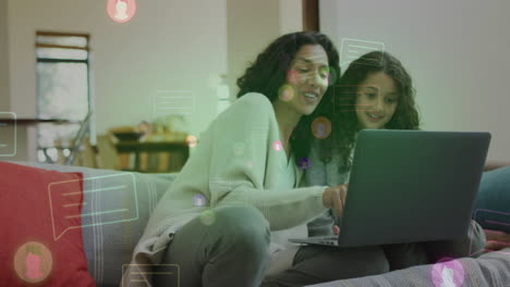 Using laptop with social media animation, mother and daughter at home