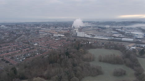 volando sobre un parque verde hacia una fábrica contaminante en las afueras de la ciudad