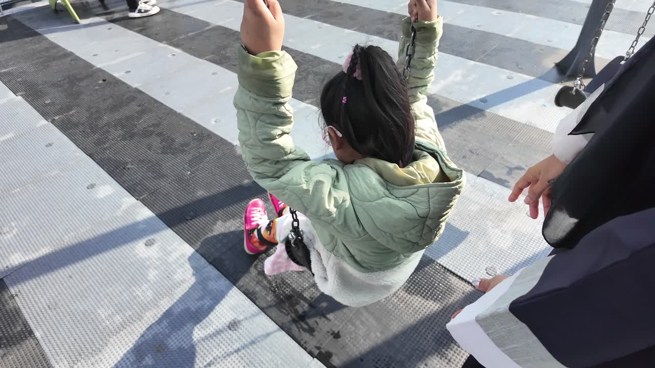 niño en un columpio en un patio de recreo