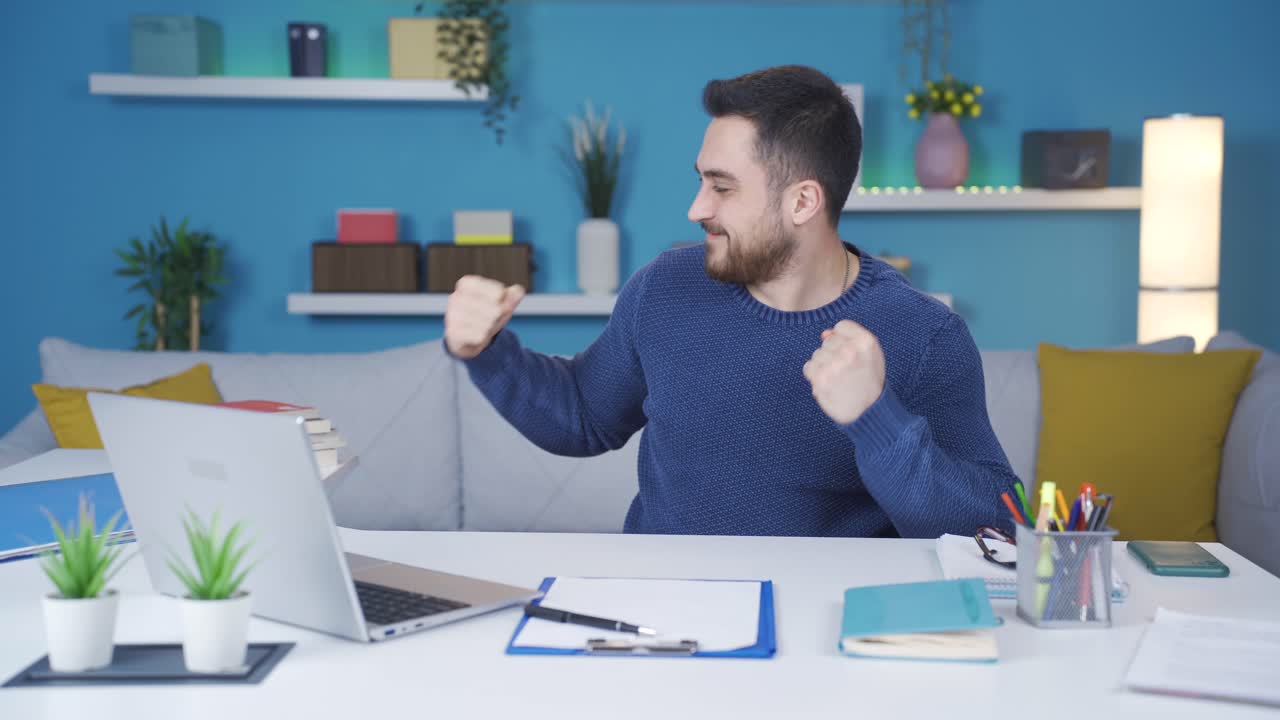 joven que trabaja desde casa felizmente trabajando.