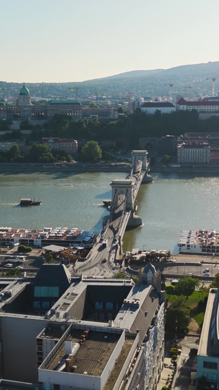 Il Ponte delle Catene Széchenyi attraversa il Danubio collegando Buda e Pest con gli edifici della città. Aerea, video verticale