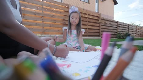 mother and daughter drawing outdoors