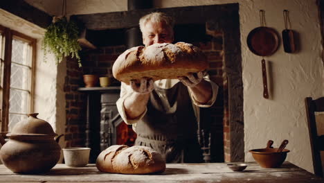 happy baker displaying fresh baked bread